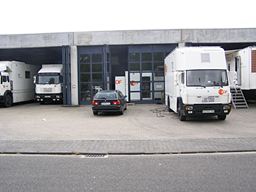 weiße Lastwagen (Übertragungswagen) vor und in der Halle
